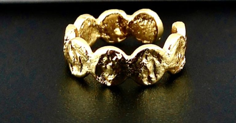 „Goldfarbener Love Local® Ring mit schwarzen Akzenten und strukturierter Oberfläche.“