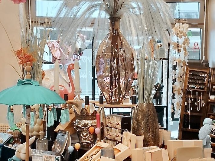 Innenansicht eines Conceptstores mit dekorativer Präsentation von Wohn- und Geschenkartikeln auf Tischen und Regalen