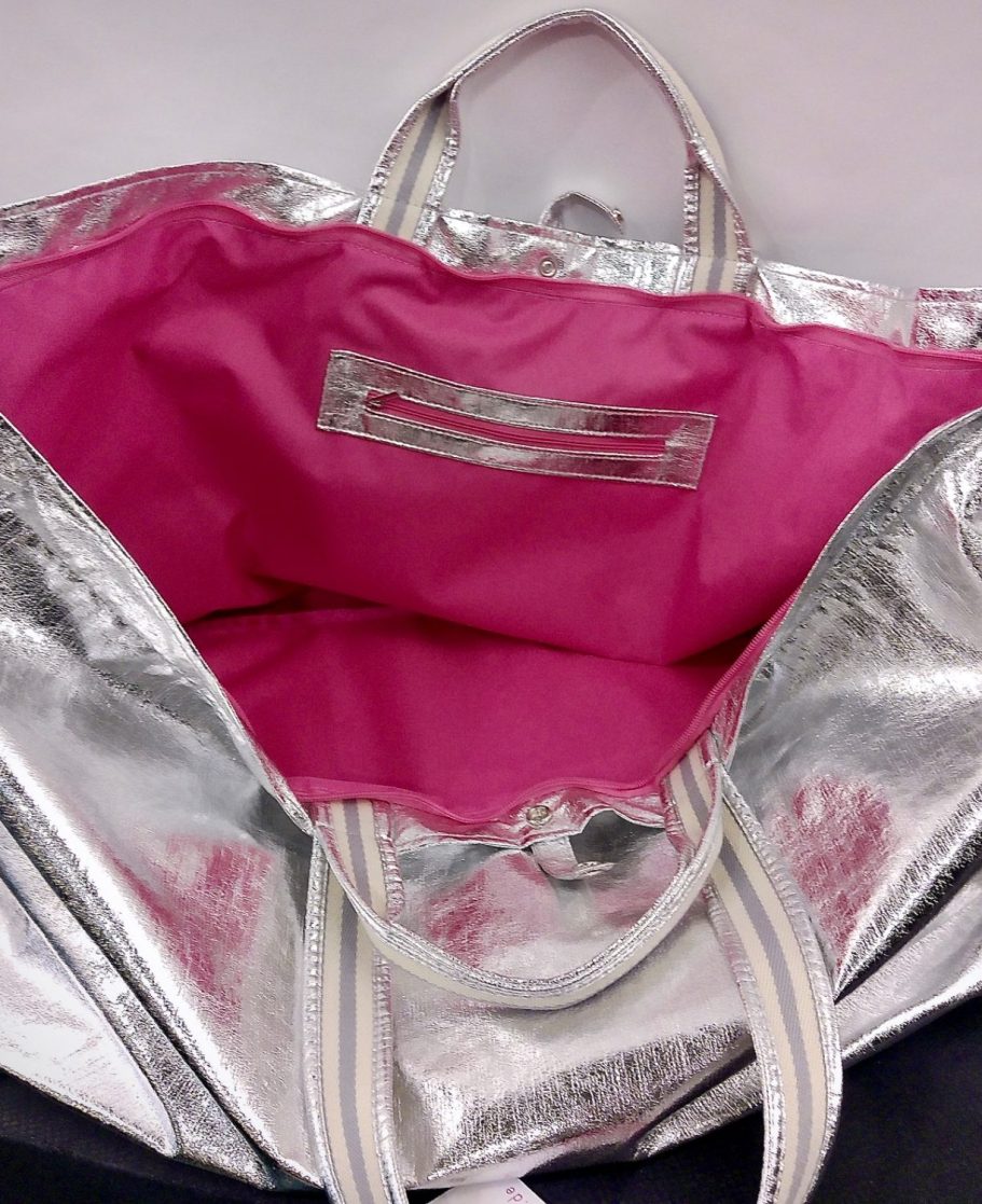 Metallisch silberne Tasche von brasibrasi® mit pinkfarbenem Innenfutter und Tragegriffen, geöffnet dargestellt
