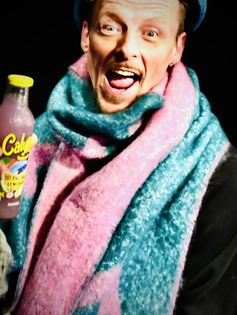 „Fröhlicher Kunde mit farbigem Schal und Calypso® Getränk im BSix® Conceptstore“