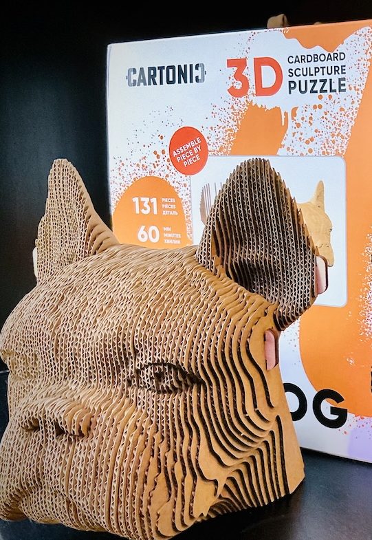 3D-Puzzle aus Karton in Form eines Hundekopfes vor der Produktverpackung